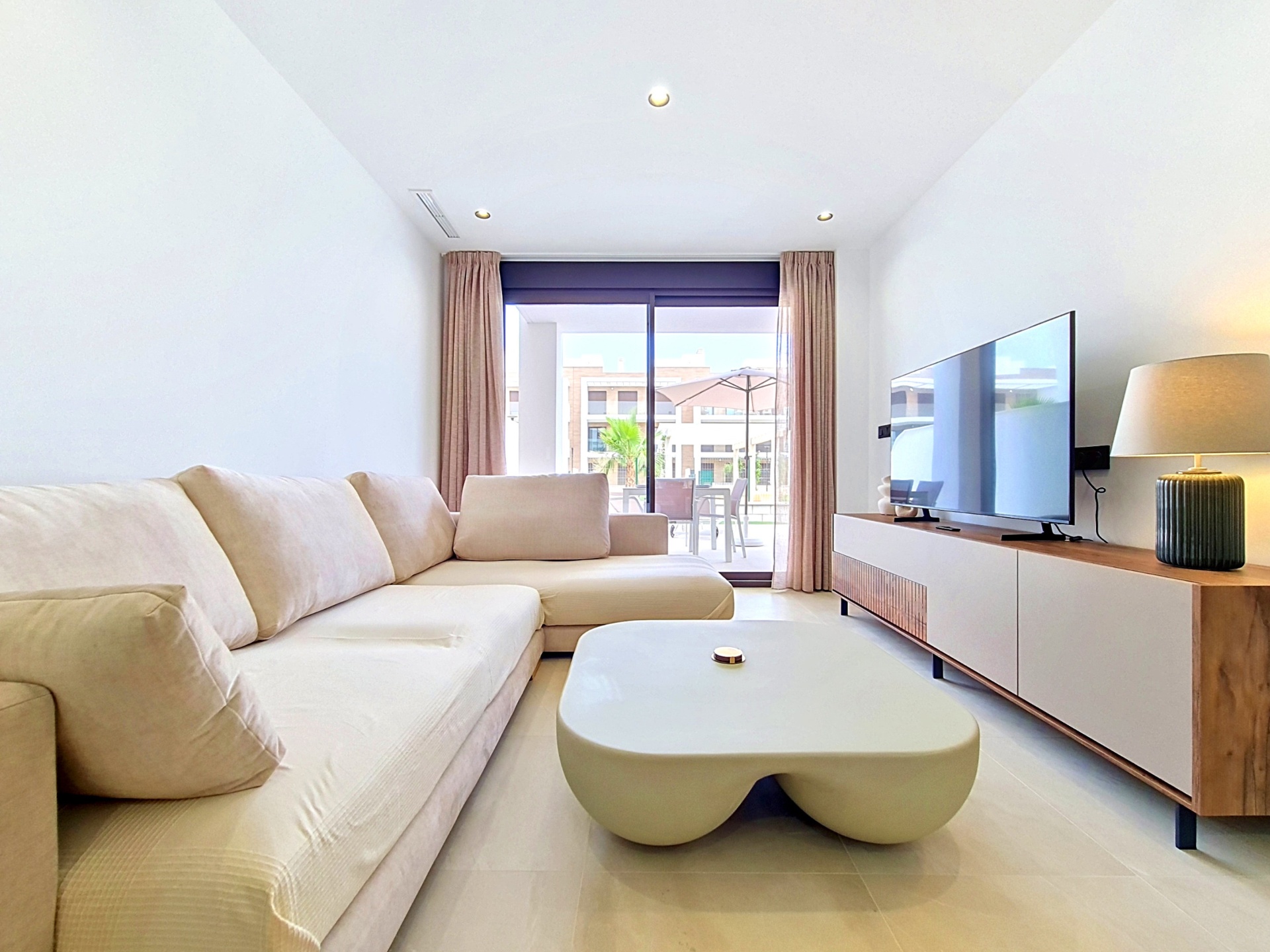 Living room with large sofa, TV and terrace doors