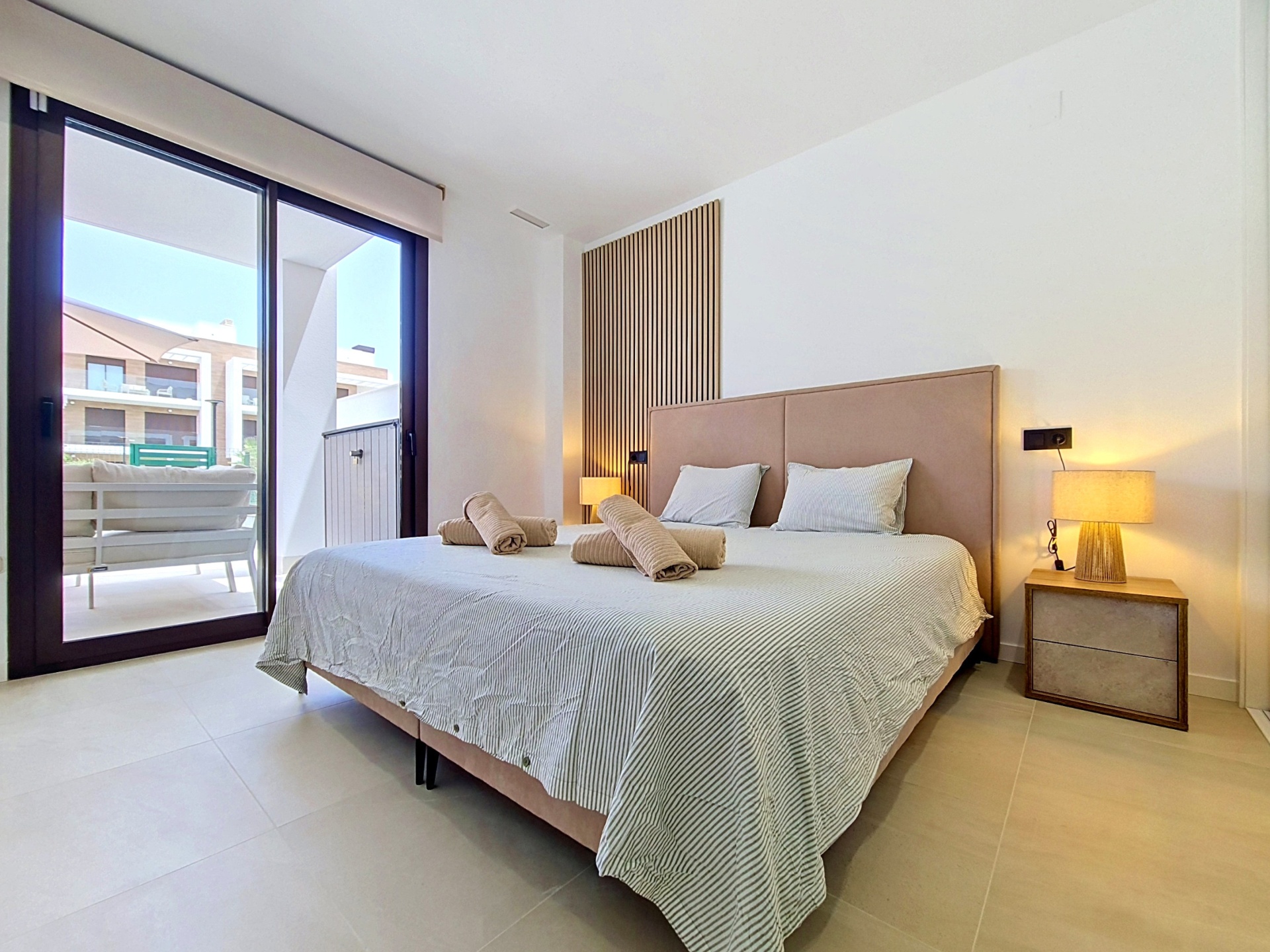 Main bedroom with upholstered headboard and terrace access