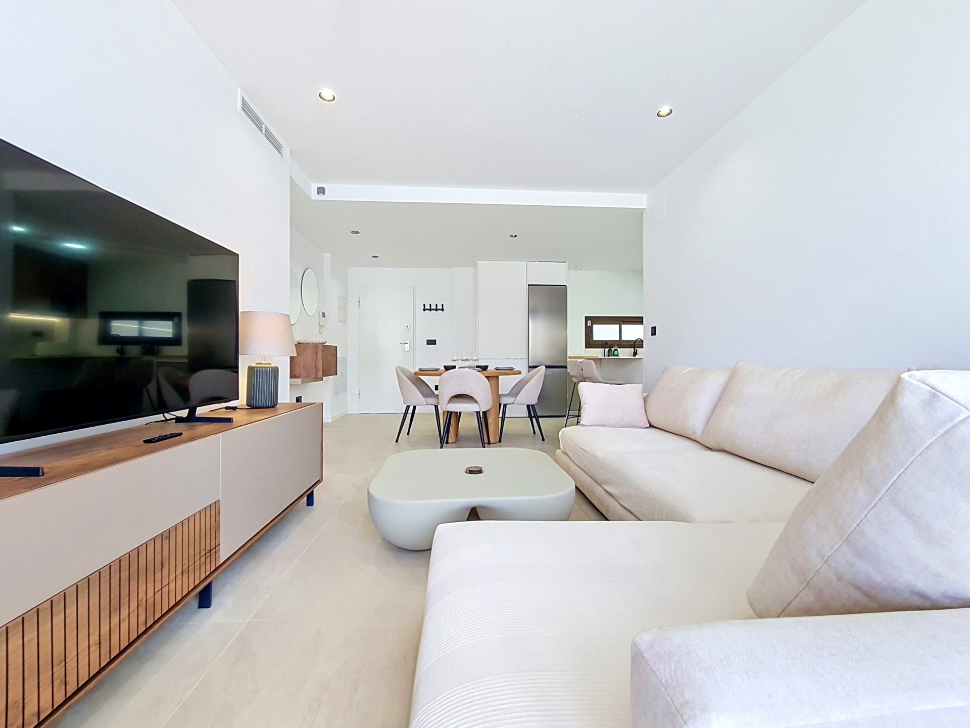 Open-plan lounge with large corner sofa and dining area behind