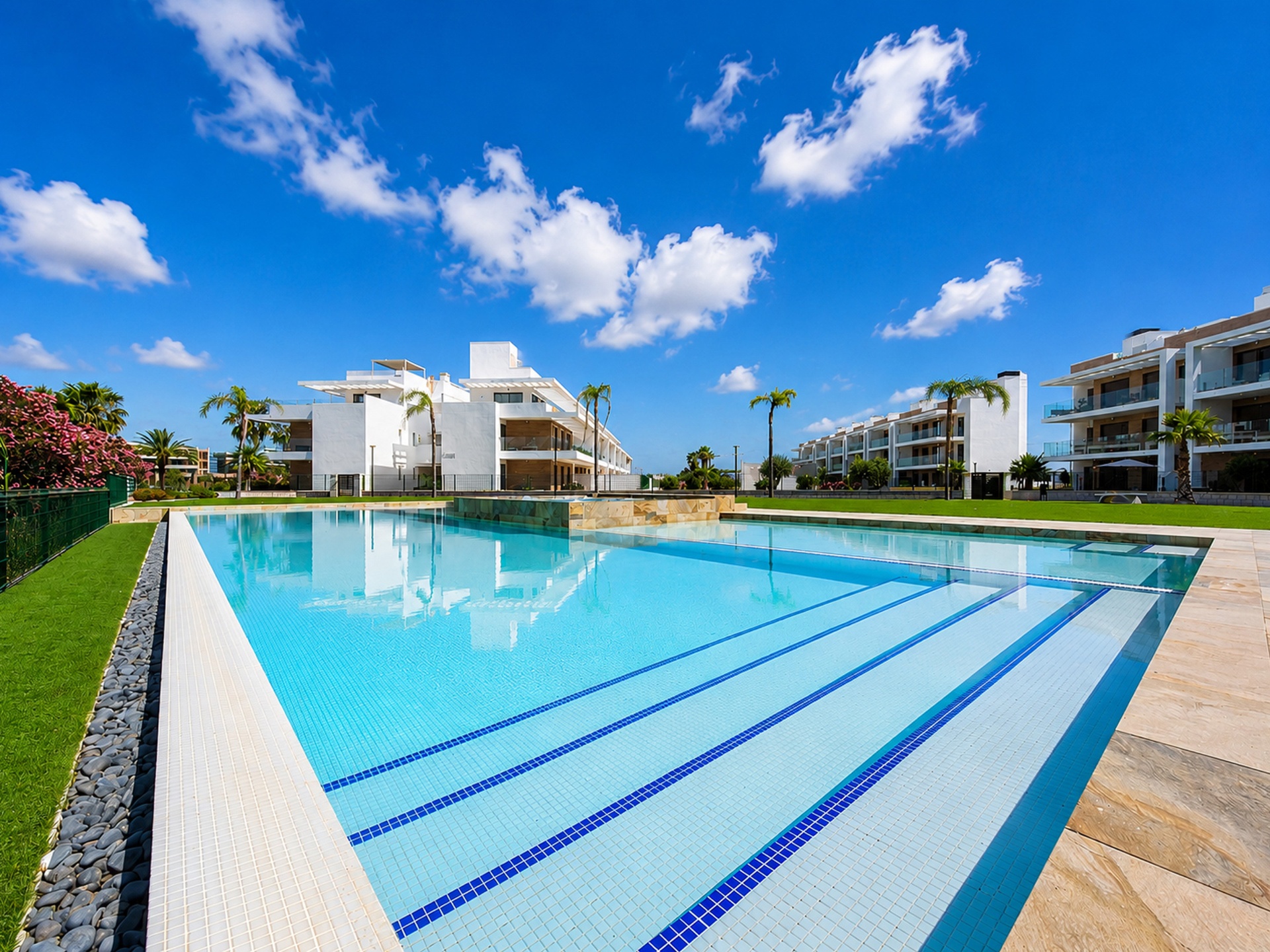 Large communal pool framed by the Velapi apartment buildings