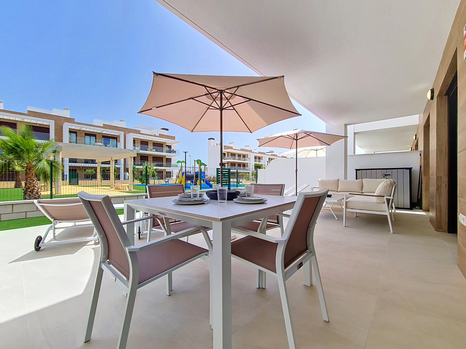 Covered terrace with outdoor dining table, sofa and loungers
